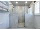 Walk-in shower with marble walls, glass doors, dual shower heads, built-in shelves, and natural light from the window at 139 W Paces Ferry Nw Rd, Atlanta, GA 30305