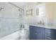 Bright bathroom featuring marble tile, a modern vanity, and a glass-enclosed shower/tub combination at 139 W Paces Ferry Nw Rd, Atlanta, GA 30305