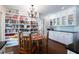 Eat-in kitchen with open shelving, white cabinetry, black countertops, wood floors, and a dining table with seating for four at 139 W Paces Ferry Nw Rd, Atlanta, GA 30305