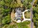 Overhead shot revealing the home's layout, with a driveway, landscaping, and small outbuilding in a wooded setting at 5780 Heards Forest Dr, Atlanta, GA 30328