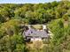 Aerial view showcases the backyard of this charming home, complete with a patio and bordered by mature trees at 5780 Heards Forest Dr, Atlanta, GA 30328