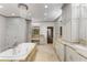 Elegant bathroom with a chandelier over the tub and marble counters at 5780 Heards Forest Dr, Atlanta, GA 30328