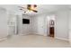 Spacious bedroom with neutral walls, carpet flooring, ceiling fan and a TV mounted on the wall at 5780 Heards Forest Dr, Atlanta, GA 30328