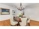 Formal dining room with chandelier, wainscoting, hardwood floors, and seating for six at 5780 Heards Forest Dr, Atlanta, GA 30328