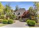 Stately home featuring beautiful landscaping, a circular driveway, and stone pillar light fixtures at 5780 Heards Forest Dr, Atlanta, GA 30328