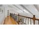 Bright hallway features hardwood floors, wrought iron railing, and natural light from skylights at 5780 Heards Forest Dr, Atlanta, GA 30328