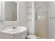 Compact bathroom with a pedestal sink, shower, and built-in shelving for storage at 135 Adair Se Ave, Atlanta, GA 30315