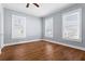 Light-filled bedroom featuring hardwood floors, a ceiling fan, and multiple windows at 135 Adair Se Ave, Atlanta, GA 30315