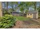 Spacious backyard with a lush lawn and mature trees featuring home and a storage shed at 357 Murray Hill Ne Ave, Atlanta, GA 30317