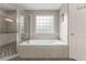 Bathroom featuring a soaking tub adjacent to the walk-in shower with glass door at 357 Murray Hill Ne Ave, Atlanta, GA 30317