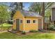 Backyard storage shed featuring a ramp entrance, white trim, and manicured landscaping at 357 Murray Hill Ne Ave, Atlanta, GA 30317