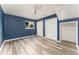 Blue bedroom featuring closet, window, and gray wood-look floors at 2315 Shamrock Dr, Decatur, GA 30032