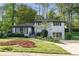 Charming two-story brick home featuring landscaped yard, fresh green grass, and mature trees at 2315 Shamrock Dr, Decatur, GA 30032