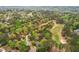 The aerial shot features the home in a tree-lined neighborhood, near a golf course at 3997 Ironhill Ln, Woodstock, GA 30189