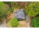 An aerial view highlighting the home's roofline and landscaping showing it nestled among mature trees at 3997 Ironhill Ln, Woodstock, GA 30189