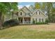 Charming two-story home with stone accents and a well-manicured front lawn and mature trees at 3997 Ironhill Ln, Woodstock, GA 30189