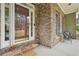 Inviting front porch featuring stone accents, two chairs, and a view of the neighborhood at 3997 Ironhill Ln, Woodstock, GA 30189