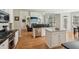 Bright kitchen featuring an island, stainless steel appliances, and hardwood floors leading to the living area at 3997 Ironhill Ln, Woodstock, GA 30189