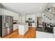 Spacious kitchen featuring white cabinetry, an island, and hardwood floors throughout at 3997 Ironhill Ln, Woodstock, GA 30189