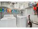 Laundry room featuring a washer, dryer, metal shelving, cleaning supplies, and vacuum at 3997 Ironhill Ln, Woodstock, GA 30189