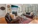 Cozy living room with a fireplace, hardwood floors, and natural light streaming through large windows at 3997 Ironhill Ln, Woodstock, GA 30189