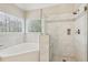 Modern bathroom featuring a corner soaking tub and seamless glass enclosed shower with window views at 3997 Ironhill Ln, Woodstock, GA 30189