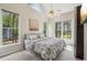 Bedroom featuring large windows, fan lighting, a bed with a patterned comforter and several windows at 3997 Ironhill Ln, Woodstock, GA 30189