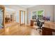 Open-concept office features natural light, wooden desk, and hardwood floors at 3997 Ironhill Ln, Woodstock, GA 30189