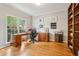 Office space features natural light, wooden desk, shelves, and hardwood floors at 3997 Ironhill Ln, Woodstock, GA 30189