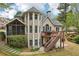 This home features a rear exterior view with a deck, screened porch, and lush landscaping at 3997 Ironhill Ln, Woodstock, GA 30189