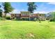 Expansive green backyard with views of the home's back exterior and wooden deck at 5666 Bob White Nw Cir, Lilburn, GA 30047