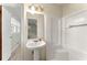 Bathroom featuring a pedestal sink and a shower with white tiled walls at 5666 Bob White Nw Cir, Lilburn, GA 30047