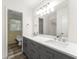 Bathroom featuring double sinks with gray cabinets and a large mirror with great lighting at 5666 Bob White Nw Cir, Lilburn, GA 30047