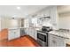 Bright kitchen with stainless steel appliances, granite countertops, white cabinets and wooden floor at 5666 Bob White Nw Cir, Lilburn, GA 30047