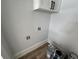 Laundry room with white upper cabinets, wood-look flooring, and washer hookups at 880 Westmont Sw Rd, Atlanta, GA 30311