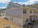 View of the rear exterior of the home with a small patio, backyard space and lush green surroundings at 5890 Vinyard Ln, Cumming, GA 30041