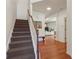 Inviting entryway with hardwood floors leading to stairs and an open-concept living space at 5890 Vinyard Ln, Cumming, GA 30041