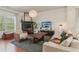 Sun-lit living room featuring hardwood floors, a fireplace, and modern decor at 5890 Vinyard Ln, Cumming, GA 30041