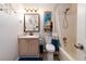 Bathroom features a shower-tub combo, vanity, and mirror with wall decorations at 603 Bluff Dr, Woodstock, GA 30188