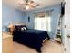 Bedroom features light blue walls, a ceiling fan, a bed, and a window for natural light at 603 Bluff Dr, Woodstock, GA 30188