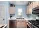 Kitchen features stainless steel appliances, light wood cabinets, a double sink, and natural light at 603 Bluff Dr, Woodstock, GA 30188