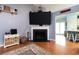 Living room with a cozy fireplace, hardwood floors, a large flat-screen TV, and comfortable furniture at 603 Bluff Dr, Woodstock, GA 30188