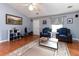 Bright living room with wood floors, comfortable armchairs, a stylish rug, and an open window with natural light at 603 Bluff Dr, Woodstock, GA 30188