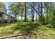 Large grassy backyard with a view of the home and some beautiful trees at 3501 Wesley Chapel Rd, Decatur, GA 30034