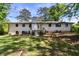 Exterior of the home from the backyard with a brick facade, chimney, steps and door at 3501 Wesley Chapel Rd, Decatur, GA 30034