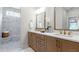 Elegant bathroom with double vanity, quartz countertops, and a marble tiled shower with bench at 4220 Provenance Trl, Cumming, GA 30028