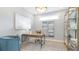 Cozy home office with a modern desk, comfortable seating, and stylish shelving unit at 4220 Provenance Trl, Cumming, GA 30028