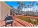 Outdoor deck featuring a grill and a beautiful view of the fenced backyard and wooded area at 46 Centerport Dr, White, GA 30184