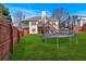 Large backyard featuring a trampoline, spacious lawn, and covered deck perfect for Gathering activities at 46 Centerport Dr, White, GA 30184