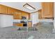 Kitchen with granite countertops, stainless steel appliances, and stylish wooden cabinets at 46 Centerport Dr, White, GA 30184